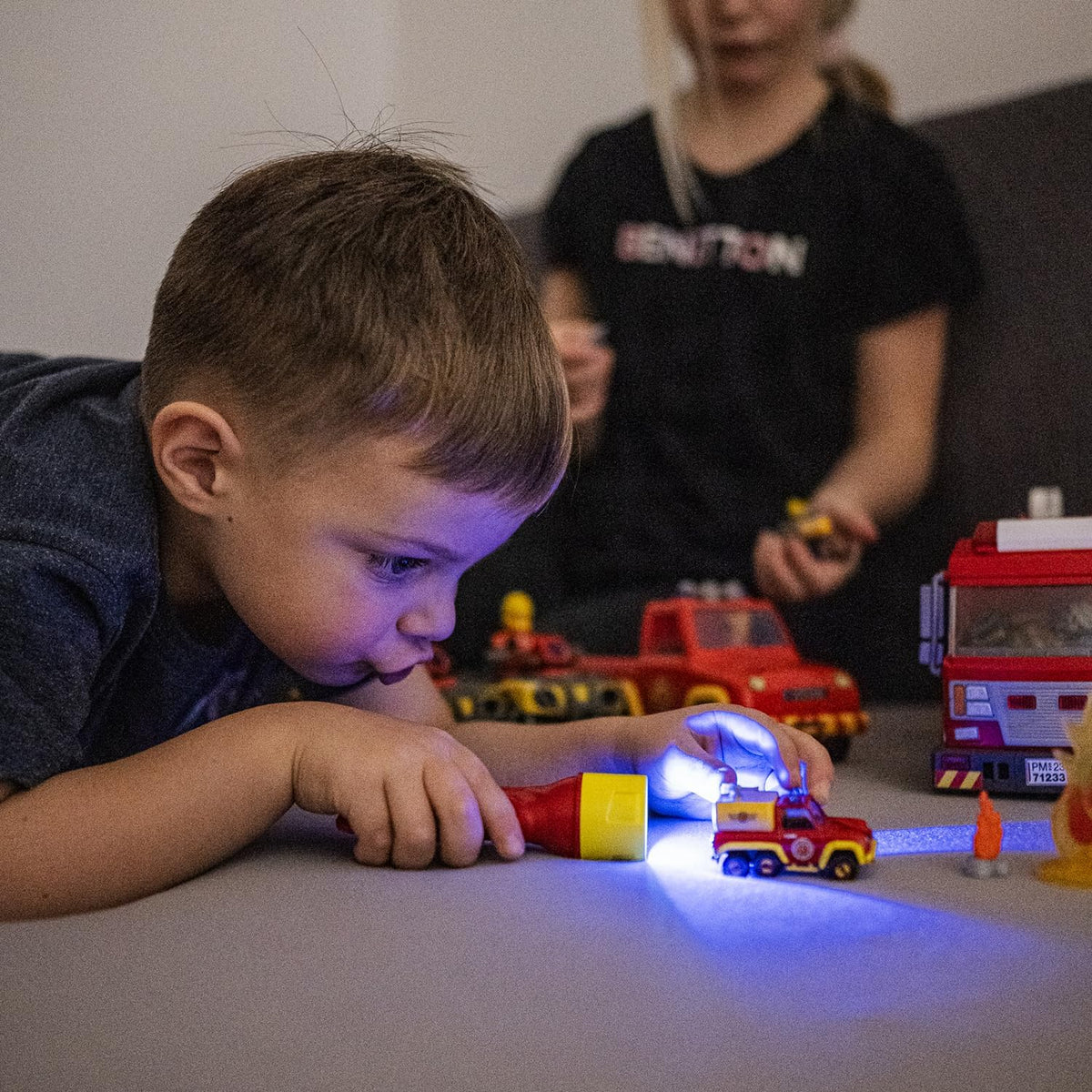 KIDBEAM4 Red Fireで消防車のおもちゃを照らして遊ぶ子ども